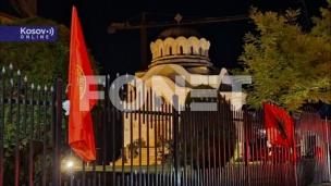 Zastave OVK na ogradi crkve 